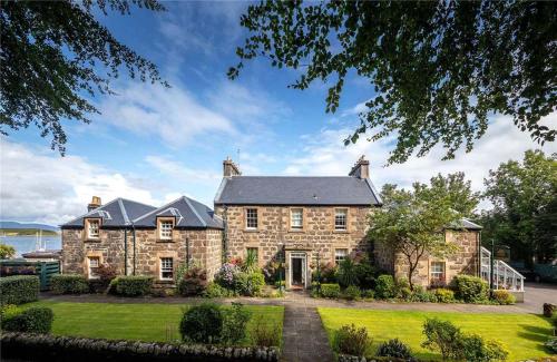 a large stone house with a large yard at The Manor House in Oban