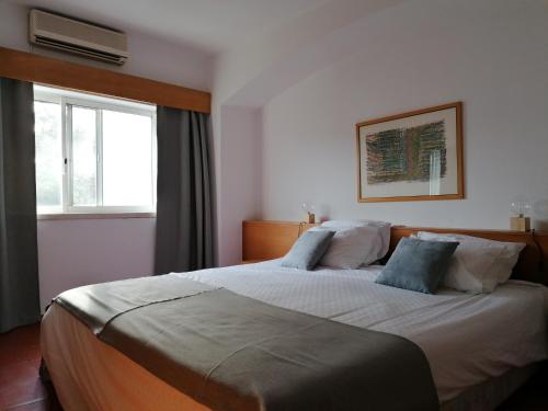 una camera con un grande letto e una finestra di Quinta do Lago Villa and Golf a Quinta do Lago