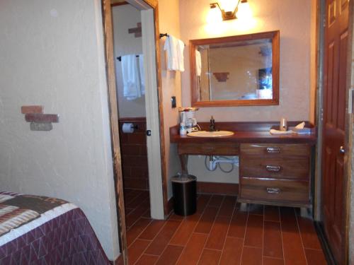 a bathroom with a sink and a mirror at Grand Canyon Inn and Motel - South Rim Entrance in Valle