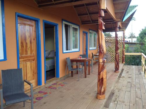 a house with a deck with a table and chairs at Hotel Taura'a in Hanga Roa