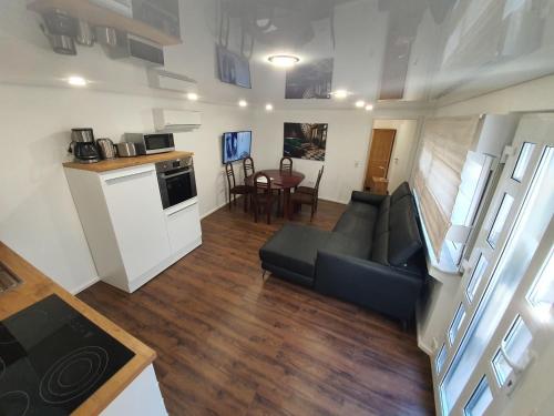 a living room with a couch and a kitchen at Handwerkerwohnung - Monteurunterkunft in Crumstadt