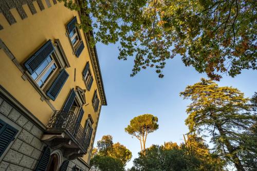 a yellow building with a balcony and a tree at Villa Ines charme near Lucca in Altopascio