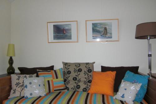 a bedroom with a bed with pillows and pictures on the wall at Lentemaheerd in Uithuizermeeden