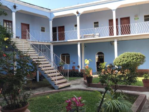een groot wit gebouw met trappen in een tuin bij Hotel Izala in San Pedro Pochutla