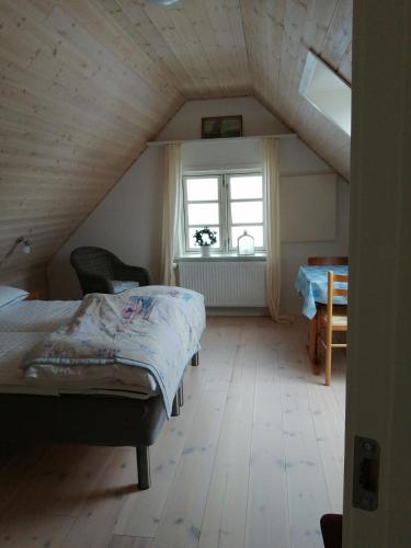 een zolderkamer met een bed en een raam bij Stenhøj Bed and Breakfast, v. Jette og Marius in Erslev