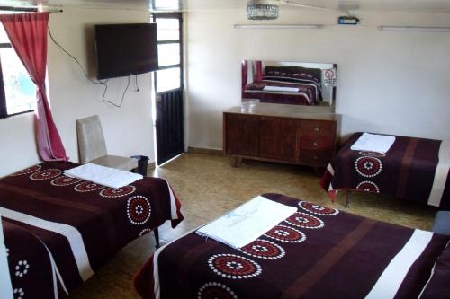 a hotel room with two beds and a mirror at Hotel Zaragoza in Puebla