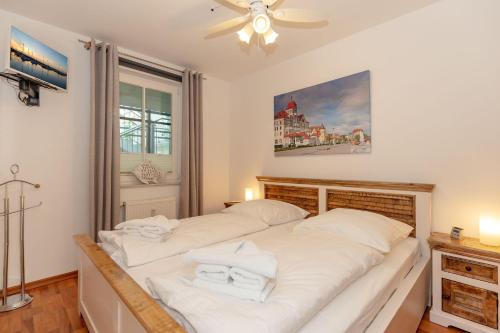 キュールングスボルンにあるHaus-Meeresblick-Wohnung-4-09-99のベッドルーム1室(白いシーツが備わるベッド2台付)