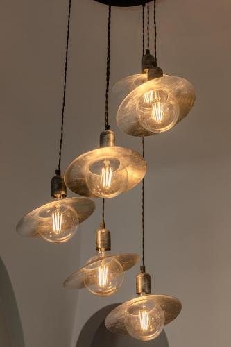 a cluster of glass lights hanging from a ceiling at NEOKLASSIKO KOUKOULI in Fira