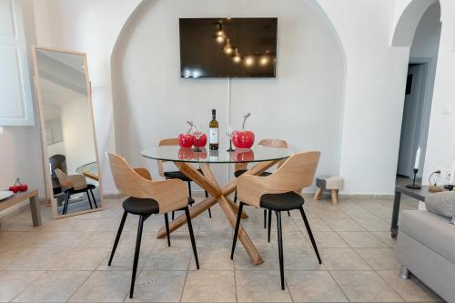 a dining room with a glass table and chairs at NEOKLASSIKO KOUKOULI in Fira