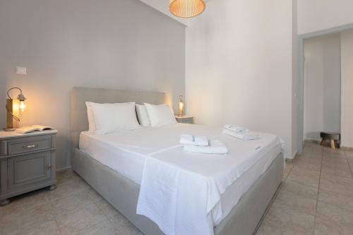 a bedroom with a white bed with two towels on it at NEOKLASSIKO KOUKOULI in Fira