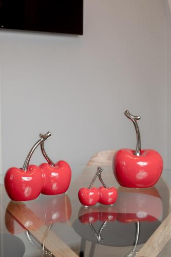 three red cherries sitting on a glass table at NEOKLASSIKO KOUKOULI in Fira