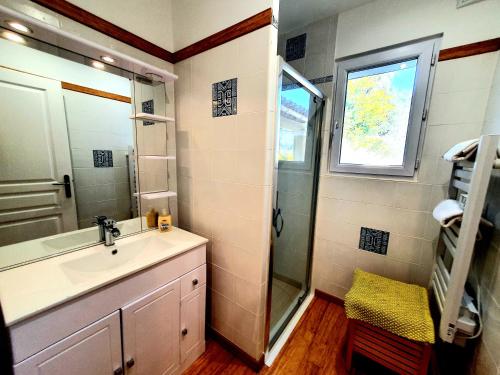 een badkamer met een wastafel, een douche en een raam bij Petit Paradis in Collobrières