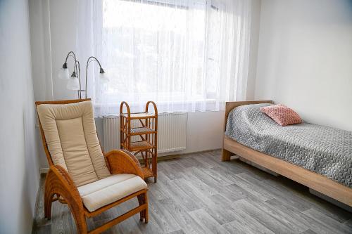 カロリンカにあるApartmán Lydieのベッドと椅子2脚と窓のある寝室