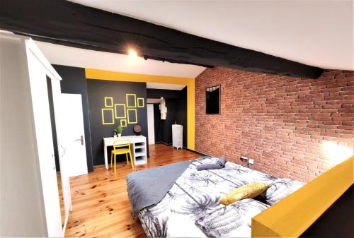 une chambre avec un lit et un mur de briques dans l'établissement LA TERRASSE DE JEANNE - Vue Magnifique - Netflix, à Toulouse