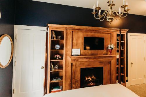a living room with a fireplace and a chandelier at The Rochester Inn in Sheboygan Falls