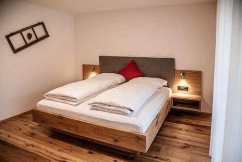a bedroom with a large bed with a red pillow at Willmüllerhof in Perca