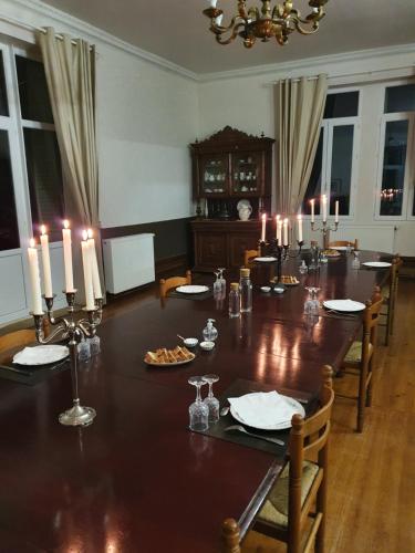 a dining room with a long table with candles on it at Chateau de Bonnevaux in Villeneuve-de-Marc