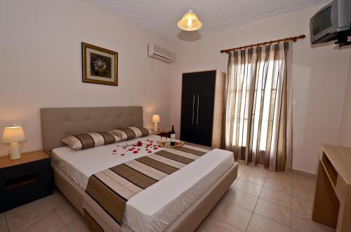 Un dormitorio con una cama con rosas rojas. en Oasis Deluxe Apartments, en Neo Klima