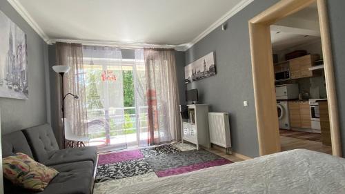 - une chambre avec un lit, un canapé et une fenêtre dans l'établissement Upes Apartment, à Jurmala