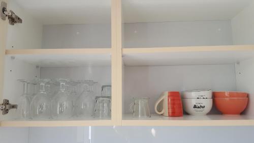 a shelf with glass jars and cups on it at SNP- PALMS in Papetoai