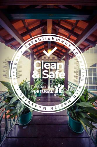 a sign in front of a building with plants at Beira Dão - Turismo Rural in Tondela