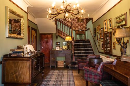 a living room with a staircase and a chandelier at Whitebridge Hotel in Whitebridge