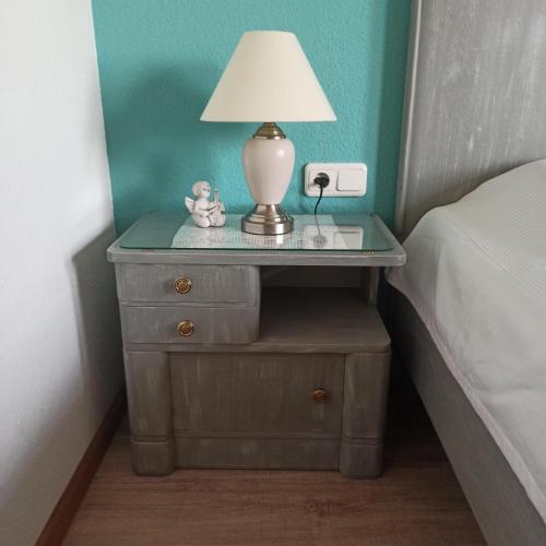 a nightstand with a lamp on it next to a bed at Zur Nachtigall in Damnatz