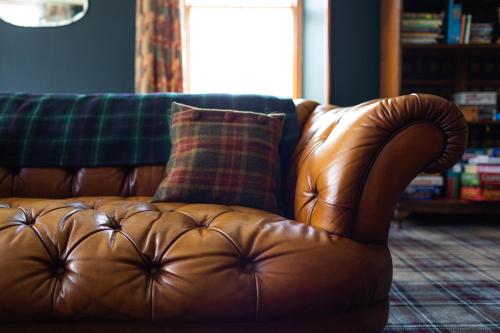 a brown leather couch sitting in a living room at Whitebridge Hotel in Whitebridge