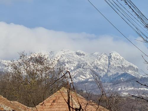 a snow covered mountain in the distance with a house at Casa Hera in Călimăneşti