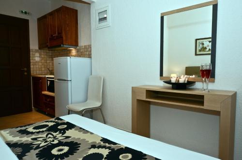 Oasis Deluxe Apartments في نيو كليما: مطبخ صغير مع طاولة مع مرآة ومغسلة