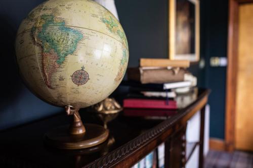 a globe sitting on top of a table with books at Whitebridge Hotel in Whitebridge