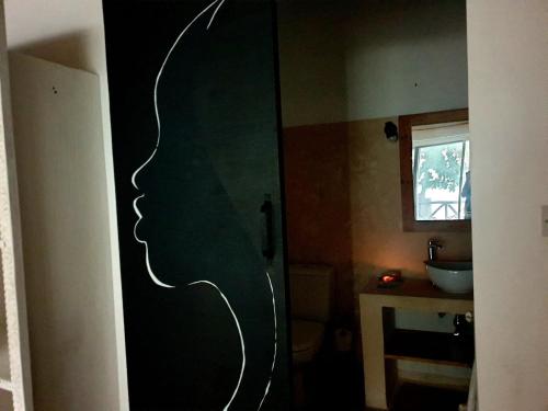 a bathroom with a door with a silhouette of a person at Ayla Beach House in Kiwengwa