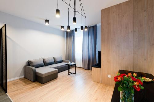 a living room with a couch and a tv at D Apartments Centrum Jurowiecka II in Białystok