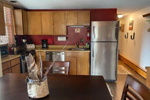 a kitchen with a stainless steel refrigerator and wooden cabinets at Best creek view and mountain view in town. Unbeatable location in Vail