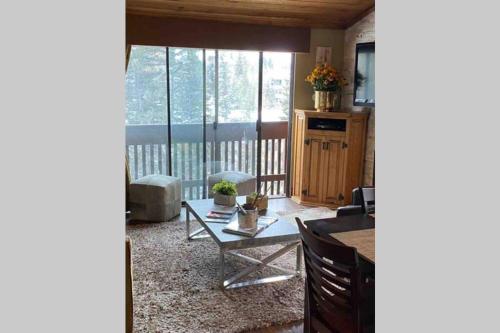 a living room with a table and a large window at Best creek view and mountain view in town. Unbeatable location in Vail