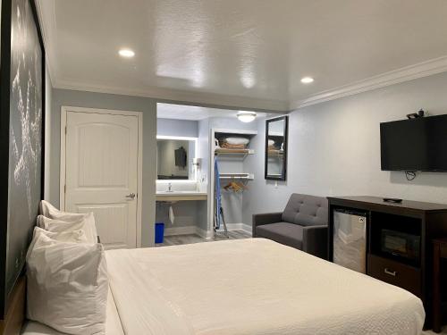 a bedroom with a bed and a couch and a television at Aura Inn Monterey in Monterey