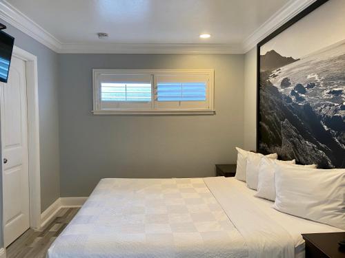 a bedroom with a large bed with a window at Aura Inn Monterey in Monterey