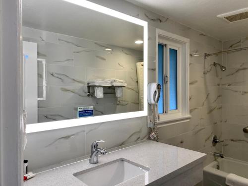 a bathroom with a sink and a mirror at Aura Inn Monterey in Monterey