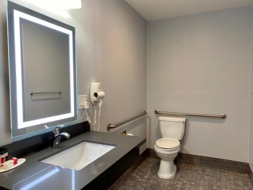 a bathroom with a sink and a toilet and a mirror at Aura Inn Monterey in Monterey