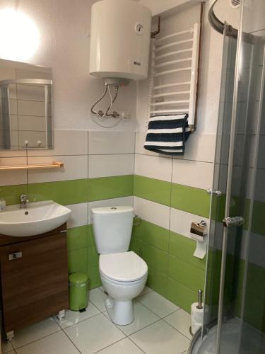 a green and white bathroom with a toilet and a sink at UNDERGROUND in Bielsko-Biała