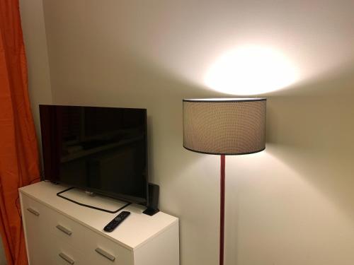 a lamp in a room with a tv and a television at VULTOR Apartments in Wrocław