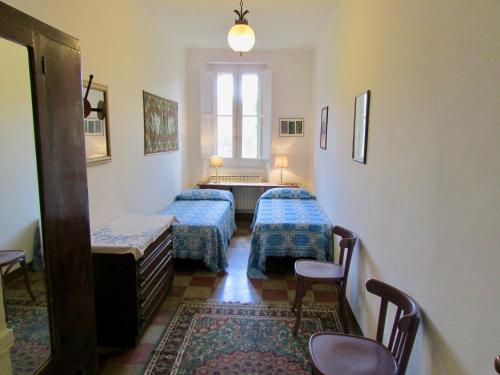 a room with two beds and a table and chairs at Agriturismo "Borgo Madonna degli Angeli" - charming cottages in the gardens ! in Tocco da Casauria