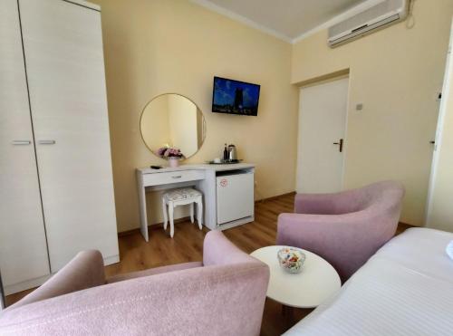 a room with a mirror and two chairs and a table at Apartments & Rooms Čakelić in Mlini