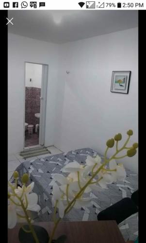 a room with a vase with white flowers in it at Flatstom in Parnaíba