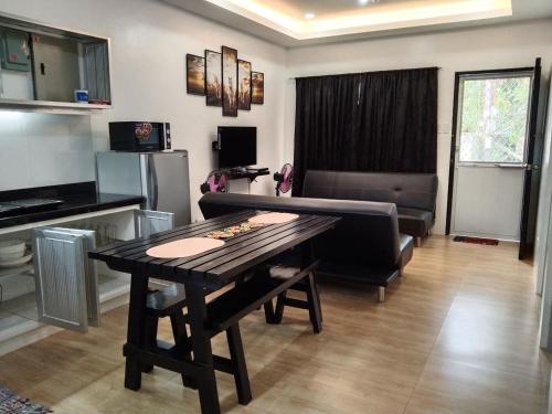 a living room with a table and a couch at 2BR townhouses good for 12pax each & NETFLIX & 100Mbps WIFI & pool resort 2min walk & 3km outside Pico de Loro Cove & Calayo Cove - with Endorsement for Pico de Loro Cove daytour & Boat-Tour & Island Hopping assistance in Nasugbu