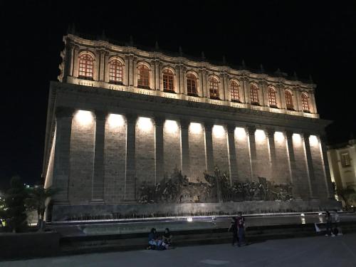 a large building with lights on it at night at Six Hotel Guadalajara Degollado in Guadalajara
