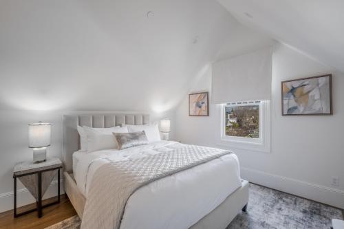 a white bedroom with a bed and two pictures on the wall at The George - Luxury Boutique Inn in Napa