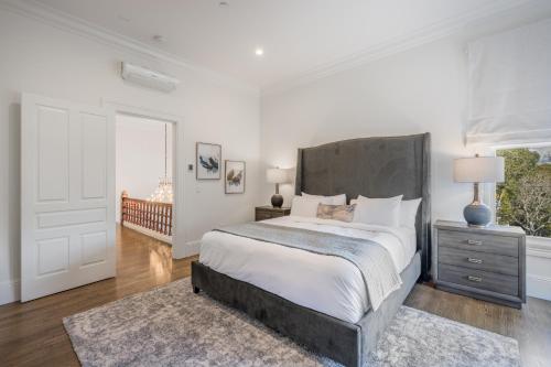 a white bedroom with a large bed and a window at The George - Luxury Boutique Inn in Napa