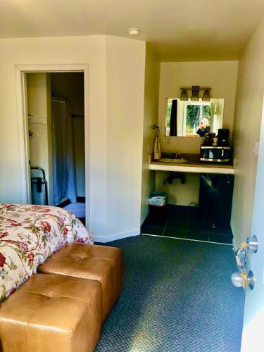 a bedroom with a bed and a brown ottoman at Carlo Creek Cabins in McKinley Park