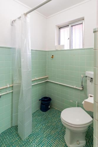 a green tiled bathroom with a toilet and a shower at Type B Room 27平米 - ウル エスポワール那覇2- in Kume